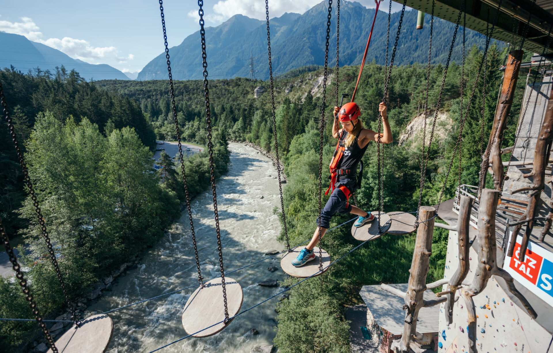 Teilnehmer im Hochseilgarten der AREA 47 im Ötztal, Tirol, balancieren über Hindernisse in luftiger Höhe