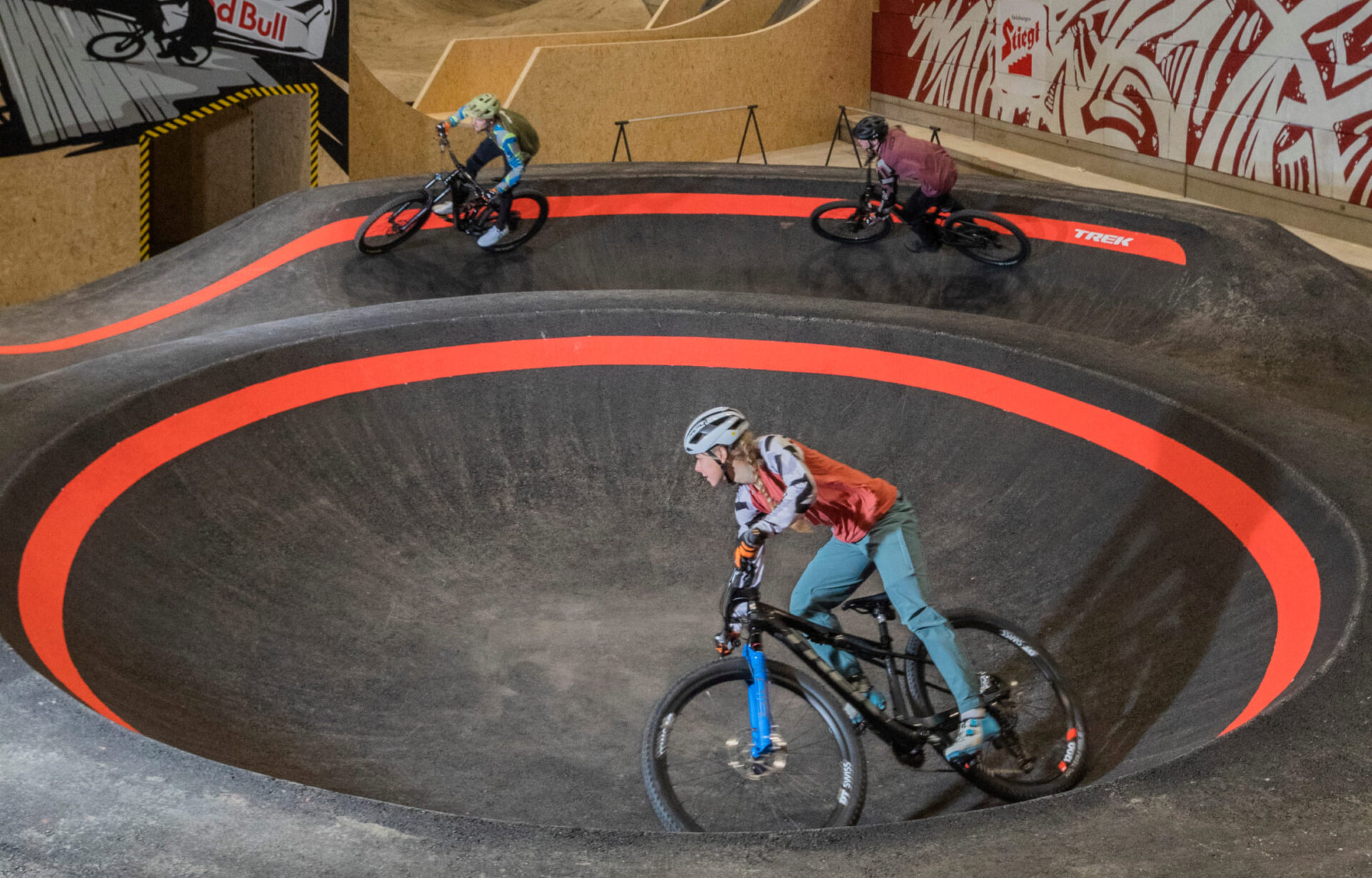Mountain bikers on a bend in the AREA 47 indoor bike park in Ötztal, Tyrol