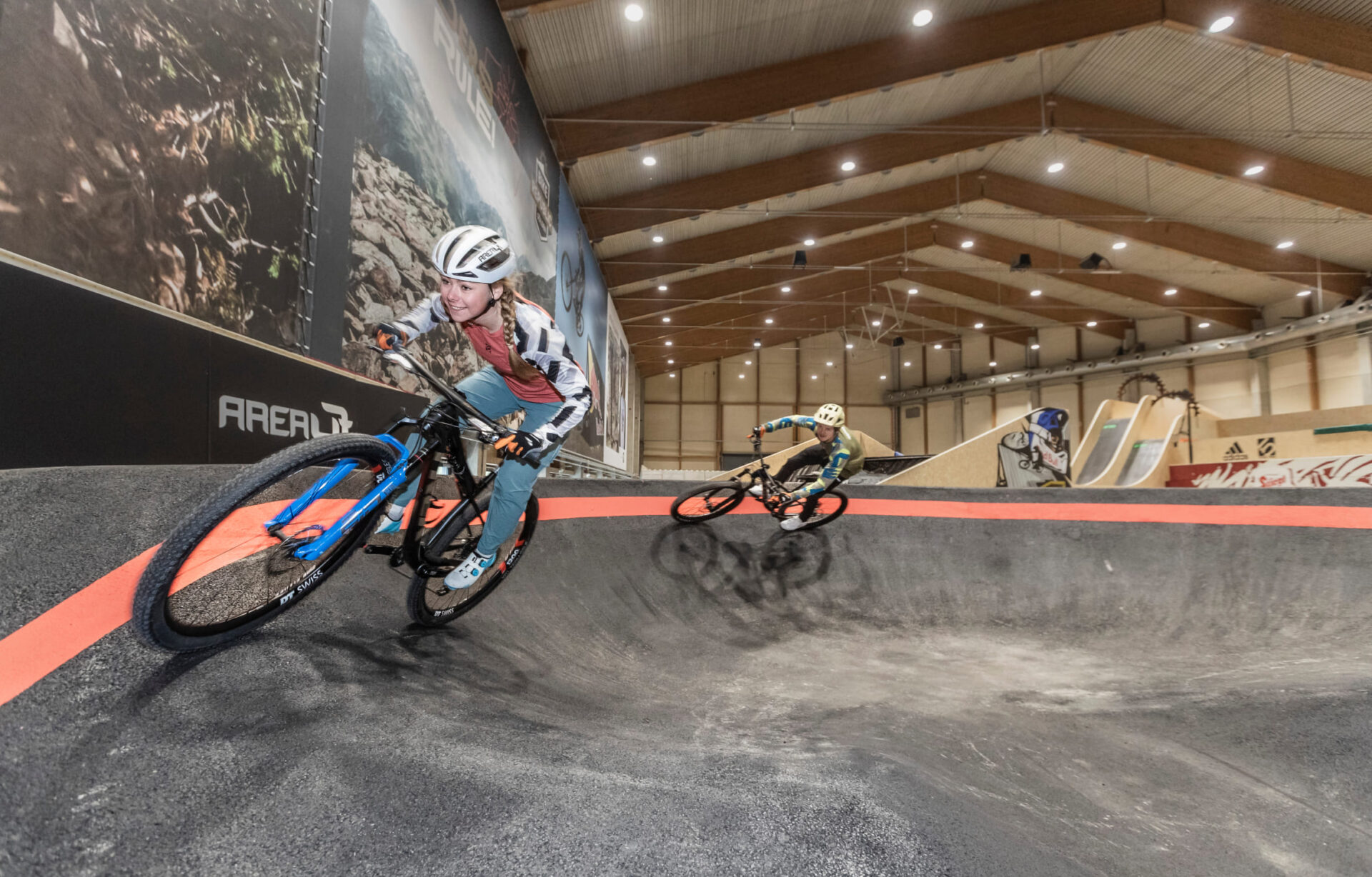 Mountain bikers on a bend in the indoor bike park at AREA 47 in Ötztal, Tyrol