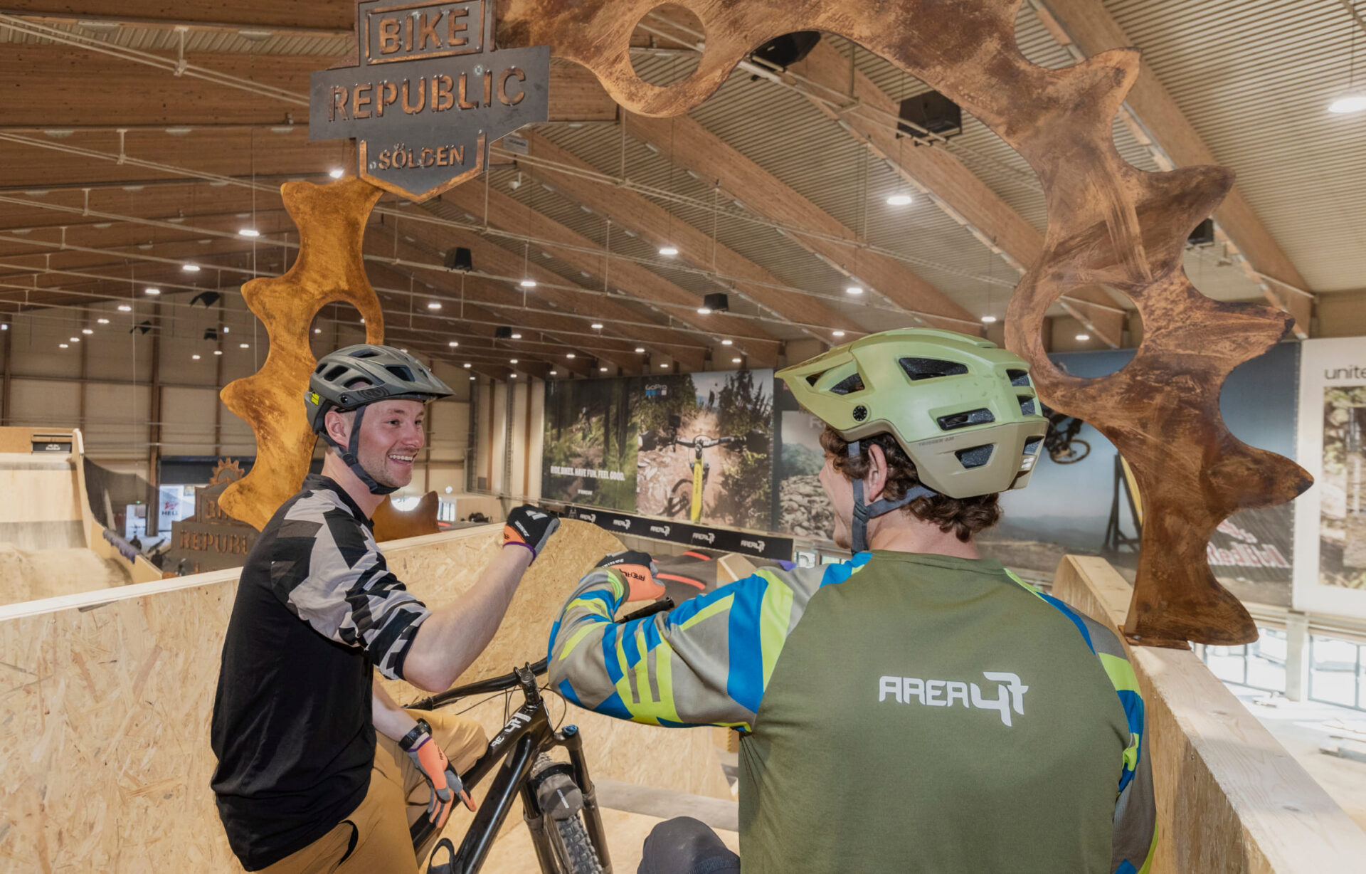 Two mountain bikers discuss their strategy in the indoor bike park at AREA 47 in Ötztal, Tyrol