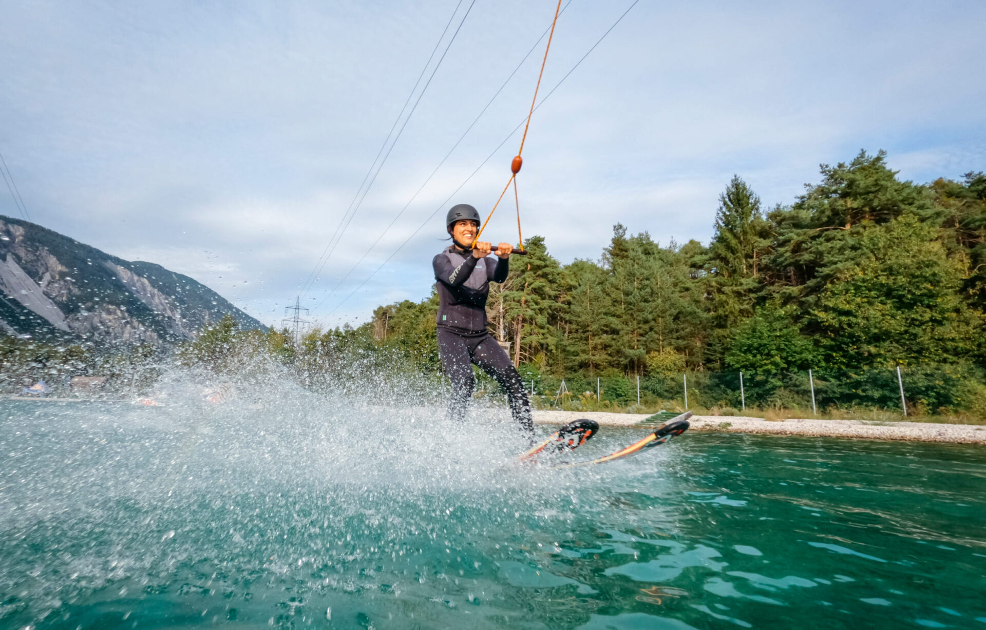 Person beim Wasserskifahren in der Wake AREA der AREA 47 im Ötztal, Tirol, mit Wasserspritzern