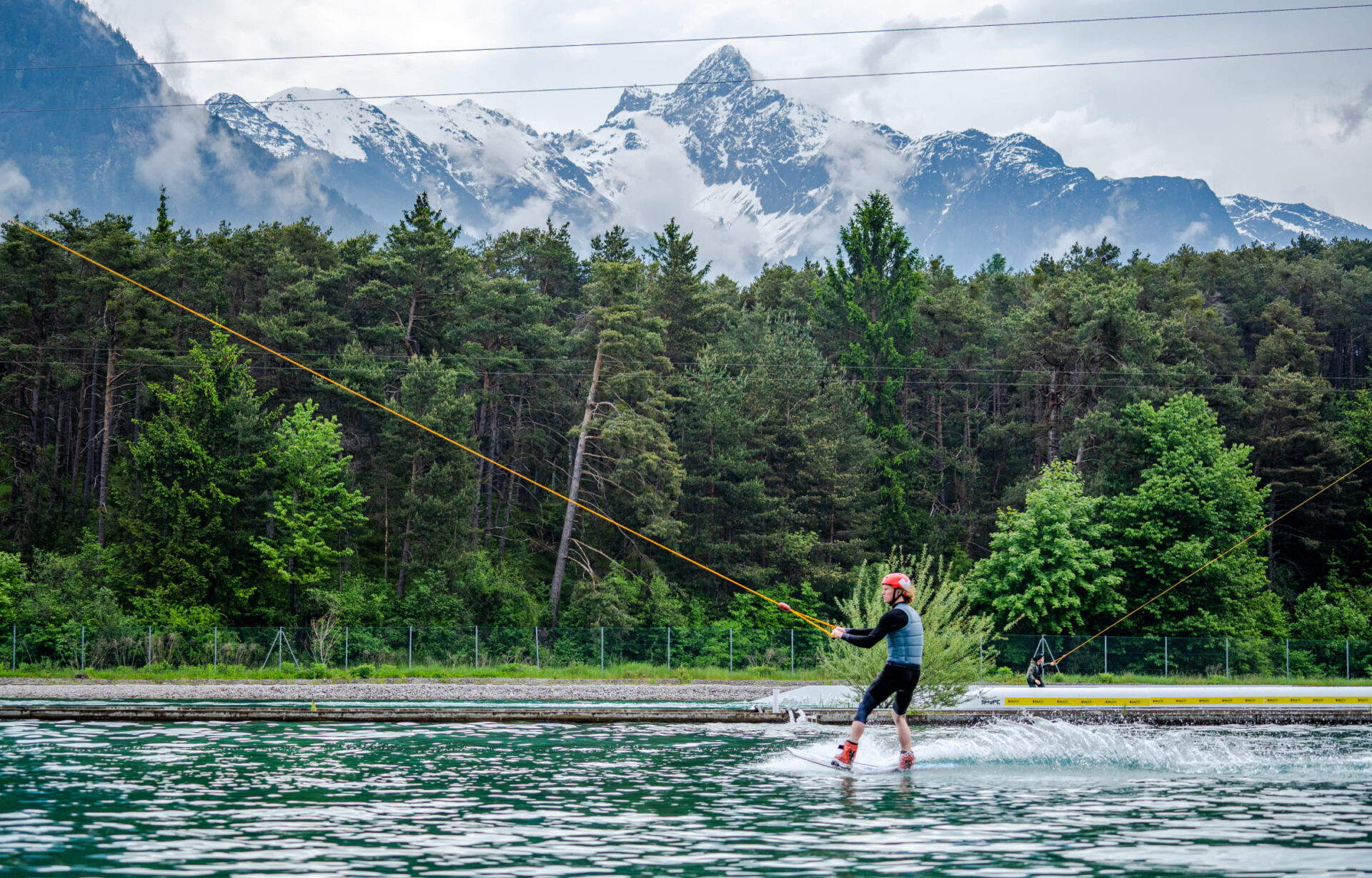 Wakeboarder fährt über die Wake AREA mit Bergkulisse in der AREA 47 im Ötztal, Tirol