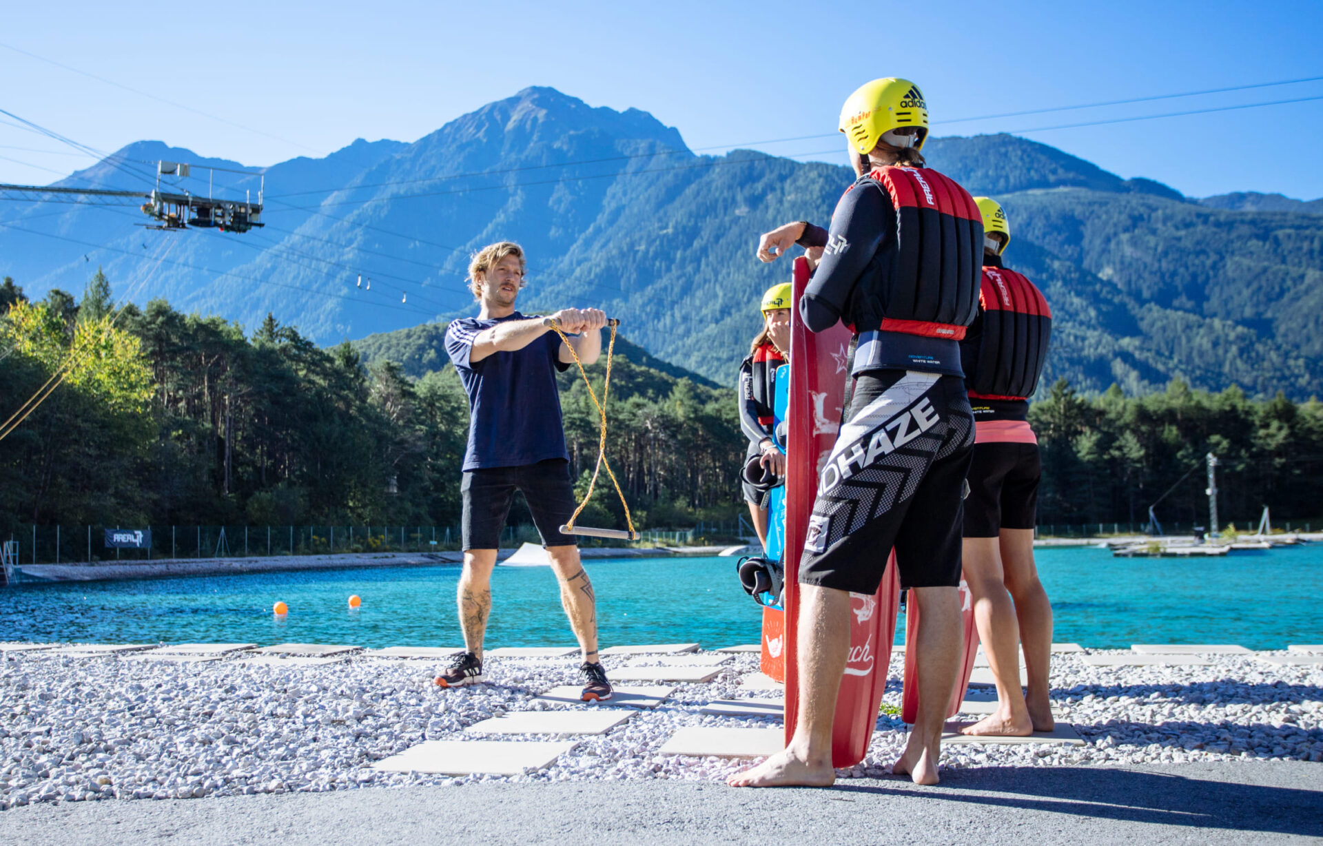 Trainer gibt Wakeboard-Anweisungen in der Wake AREA der AREA 47 im Ötztal, Tirol