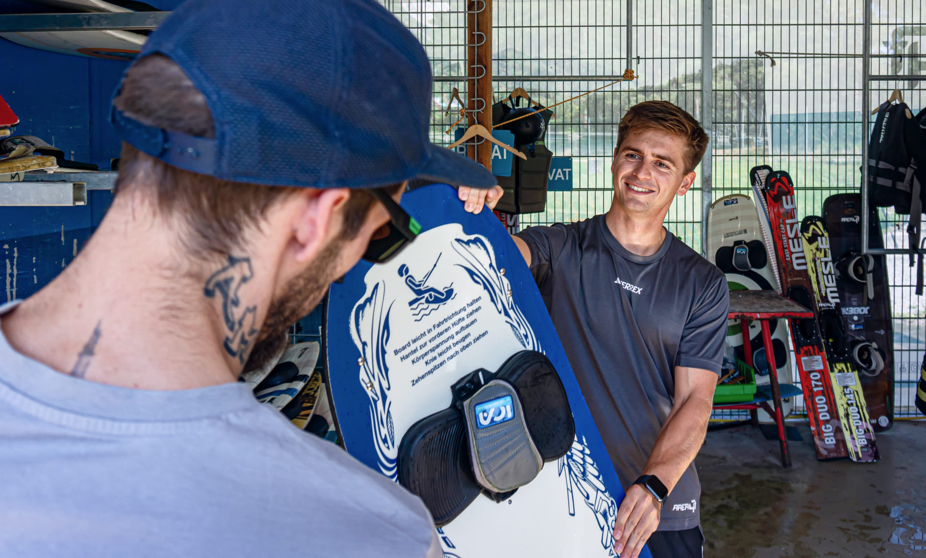 Mitarbeiter berät Besucher im Wakeboard-Verleih der AREA 47 im Ötztal, Tirol