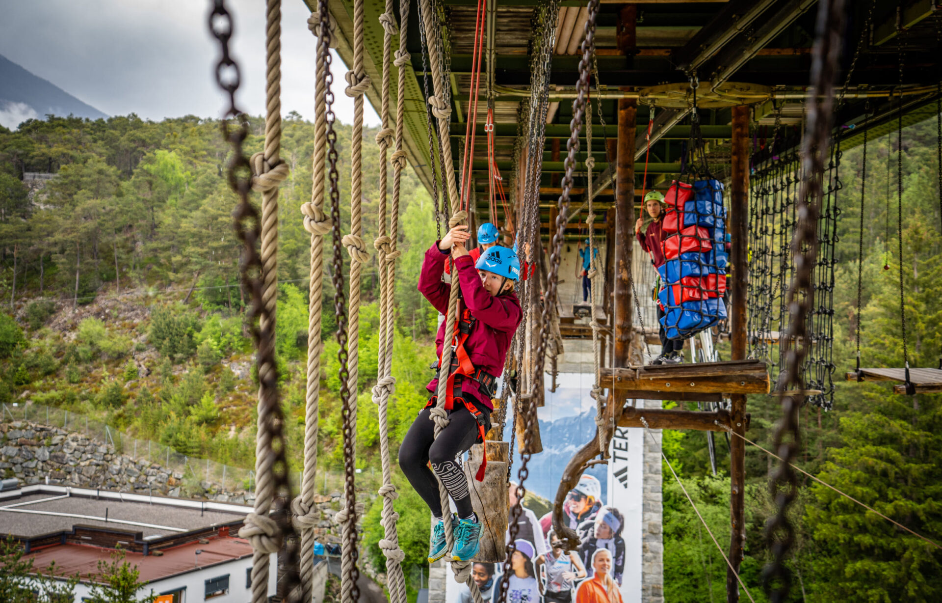 Teilnehmer im Hochseilgarten der AREA 47 im Ötztal, Tirol, balancieren über Hindernisse in luftiger Höhe