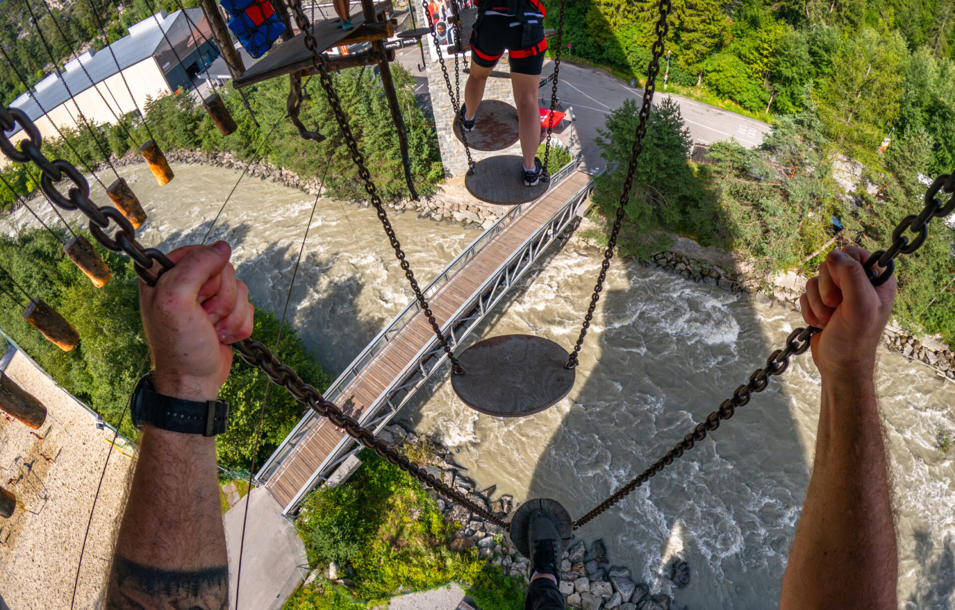 Teilnehmer im Hochseilgarten der AREA 47 im Ötztal, Tirol, balancieren über Hindernisse in luftiger Höhe