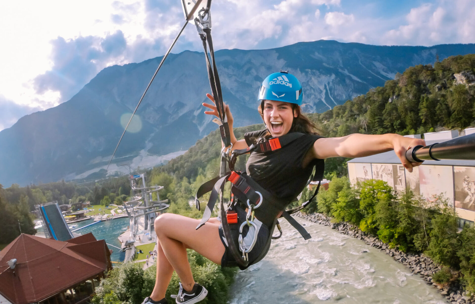 Frau mit Helm und Gurt bei einer Seilrutschenfahrt über den Fluss in der AREA 47 im Ötztal, Tirol