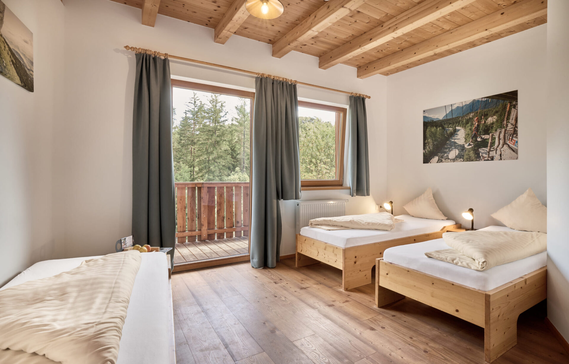 Helles Dreibettzimmer mit Balkon und Holzdesign in der AREA 47 im Ötztal, Tirol