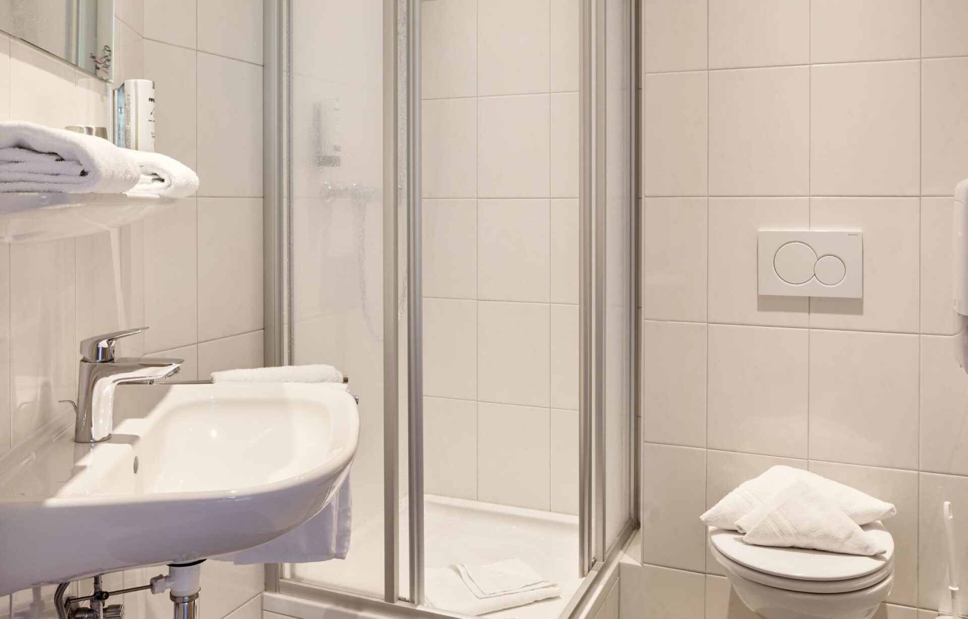 Badezimmer mit Waschbecken, Spiegel und WC in den Unterkünften der AREA 47 im Ötztal, Tirol