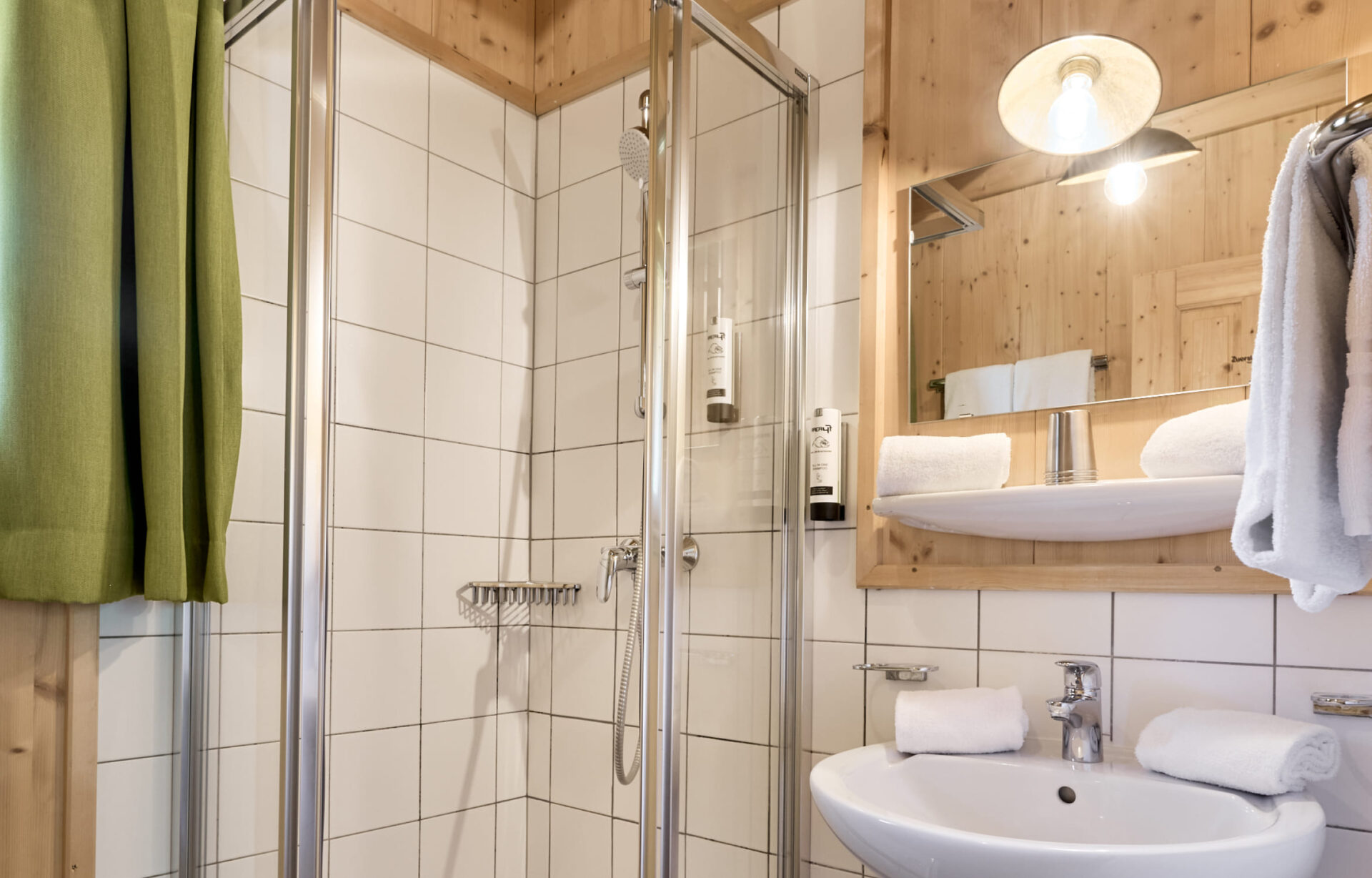 Badezimmer mit Waschbecken, Spiegel und WC in den Unterkünften der AREA 47 im Ötztal, Tirol