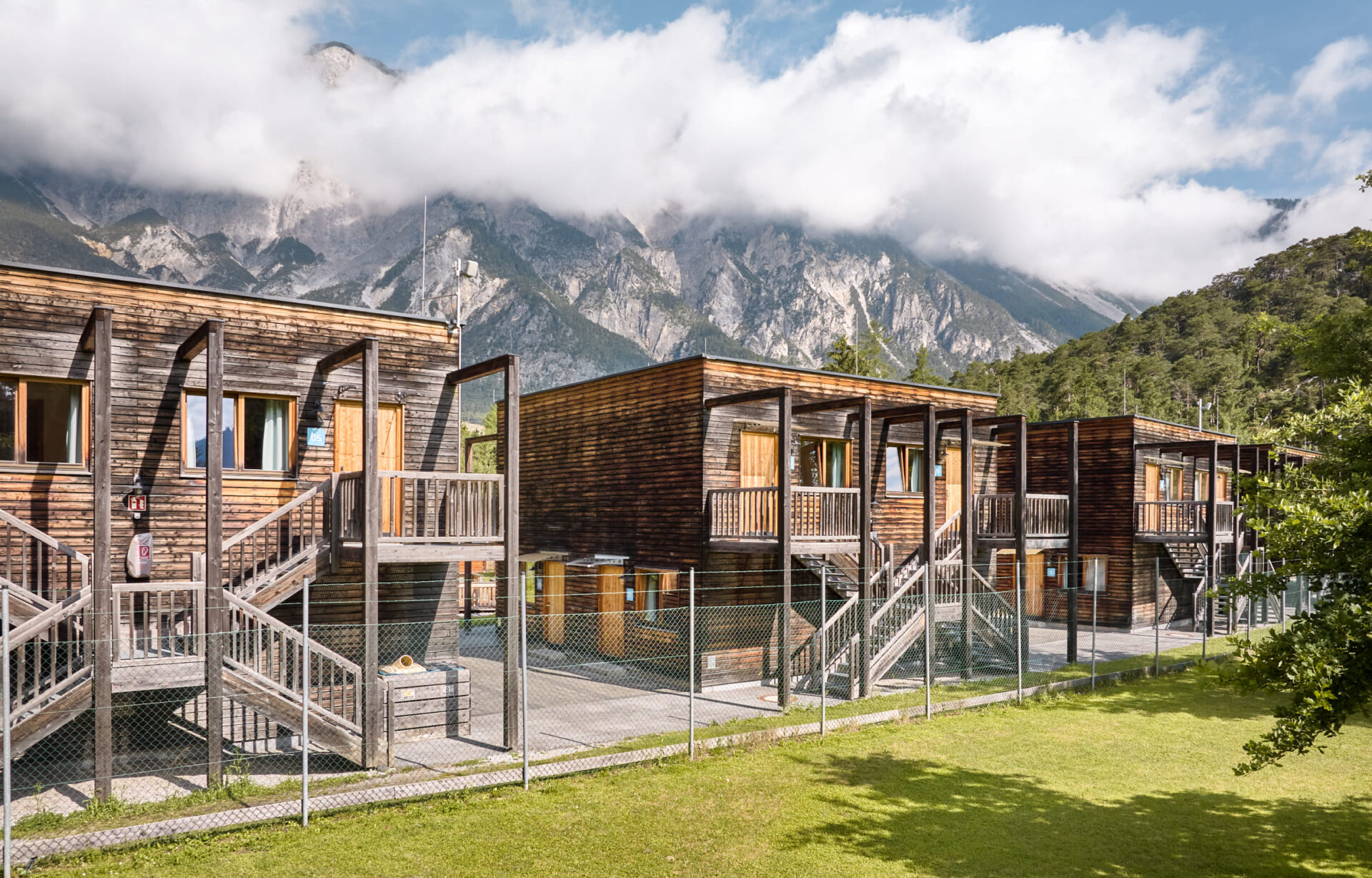 Unterkünfte der AREA 47 im Ötztal, Tirol, umgeben von Wald und Bergen