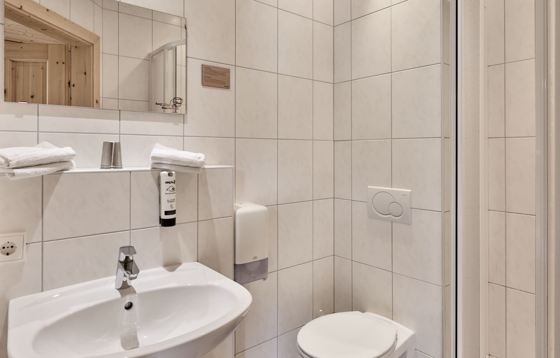 Badezimmer mit Waschbecken, Spiegel und WC in den Unterkünften der AREA 47 im Ötztal, Tirol