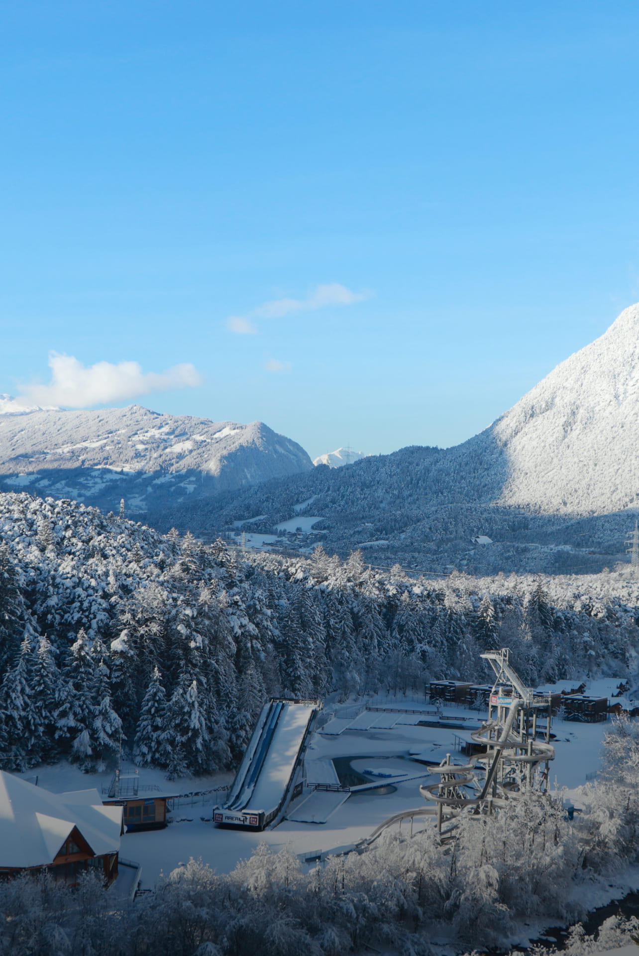 Winterliche Ansicht der schneebedeckten AREA 47 im Ötztal, Tirol, umgeben von Bergen und Wäldern