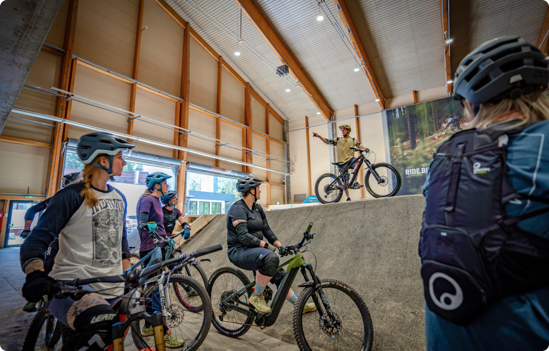 A cycling coach giving instructions from a ramp to a group of bikers at AREA 47 in Ötztal, Tyrol