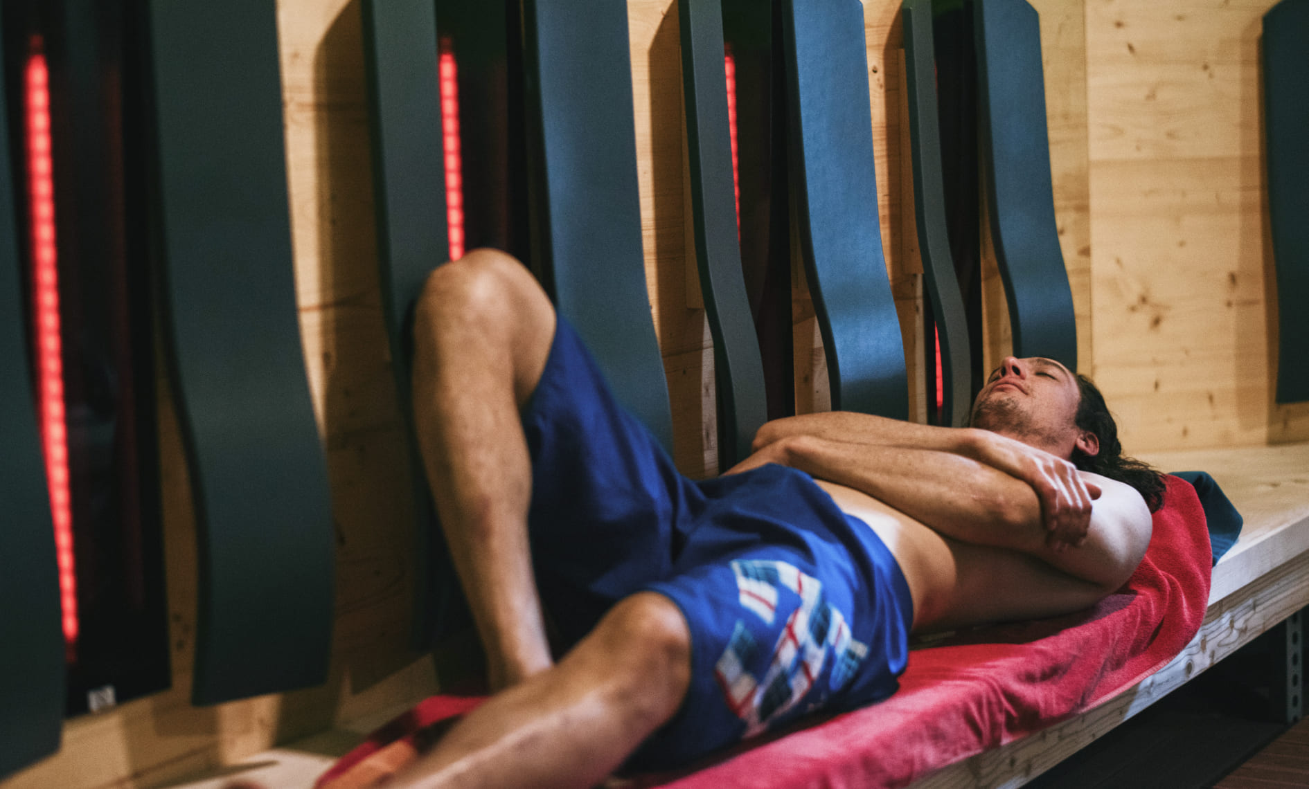 Person relaxing in the warmth lounge of AREA 47, surrounded by infrared radiators, Ötztal, Tyrol