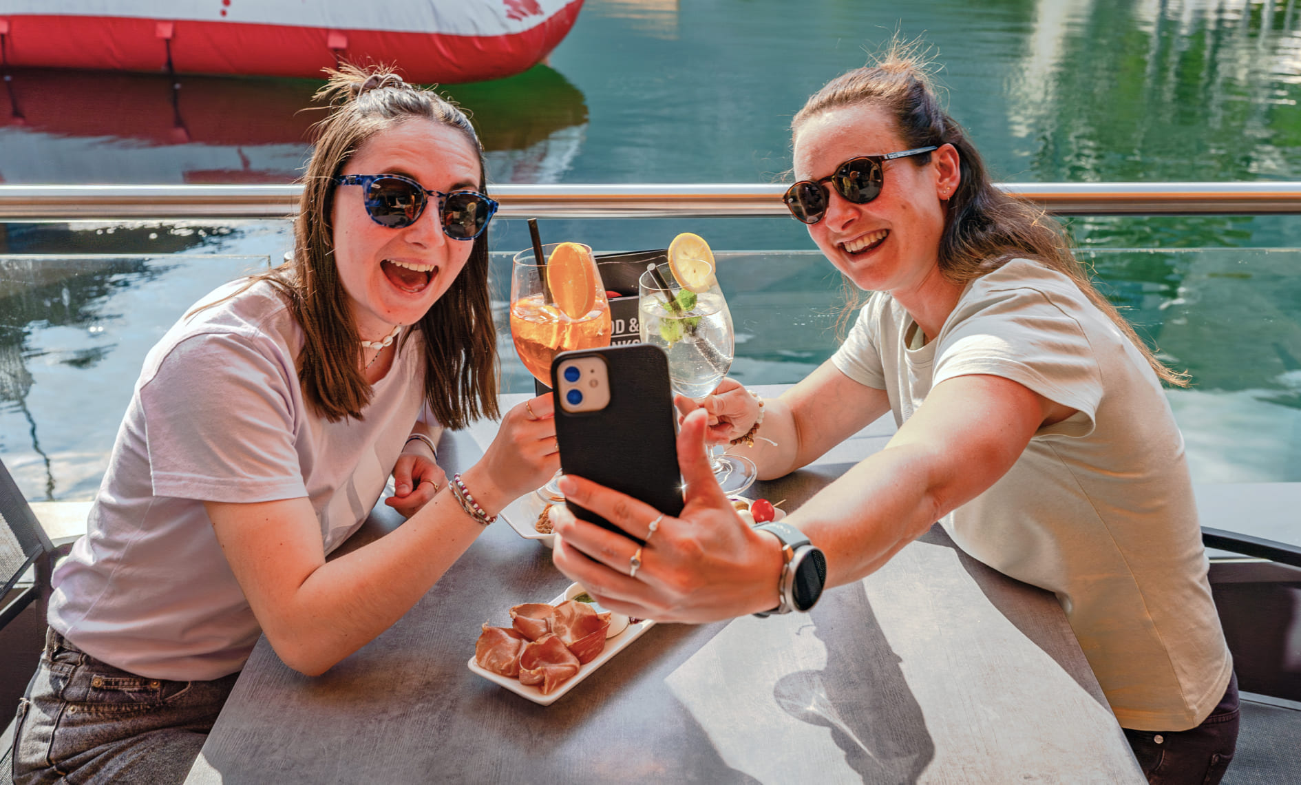 Two people take a selfie over drinks on the terrace of AREA 47, Ötztal, Tyrol