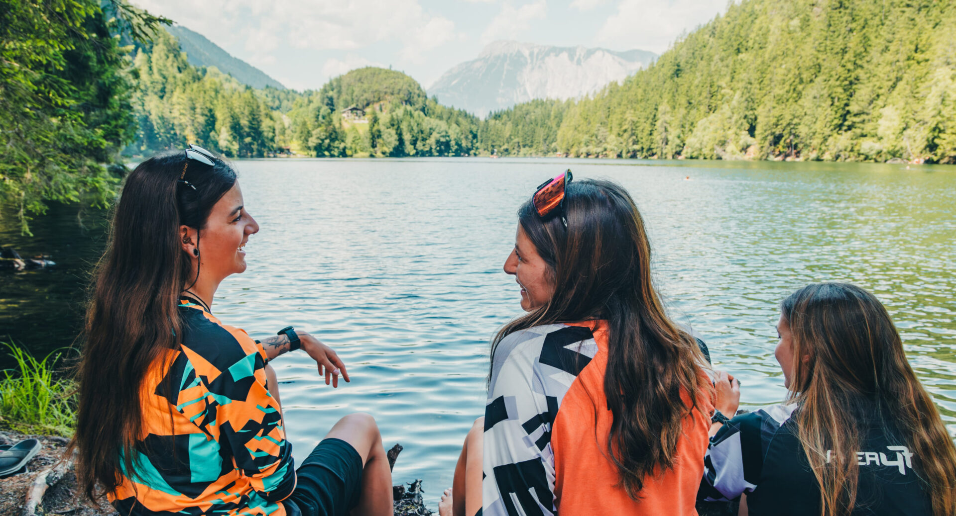 Zwei Freunde sitzen am See und unterhalten sich in der AREA 47, Ötztal, Tirol