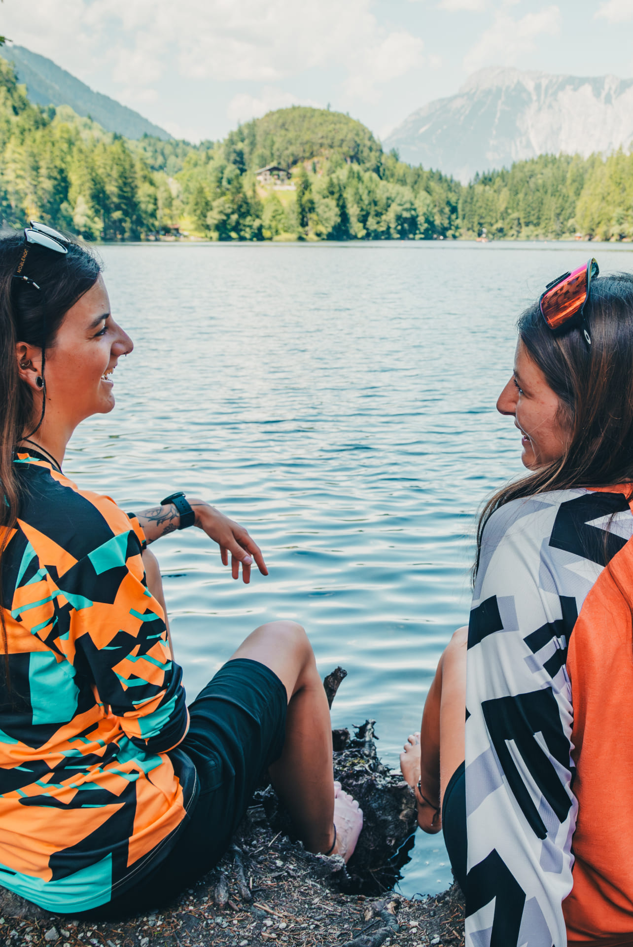 Zwei Freunde sitzen am See und unterhalten sich in der AREA 47 im Ötztal, Tirol