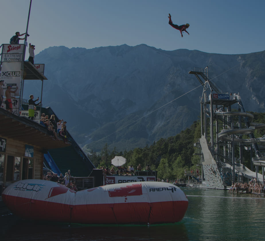 Person fliegt beim Blobbing in der AREA 47 durch die Luft, umgeben von Zuschauern, Ötztal, Tirol