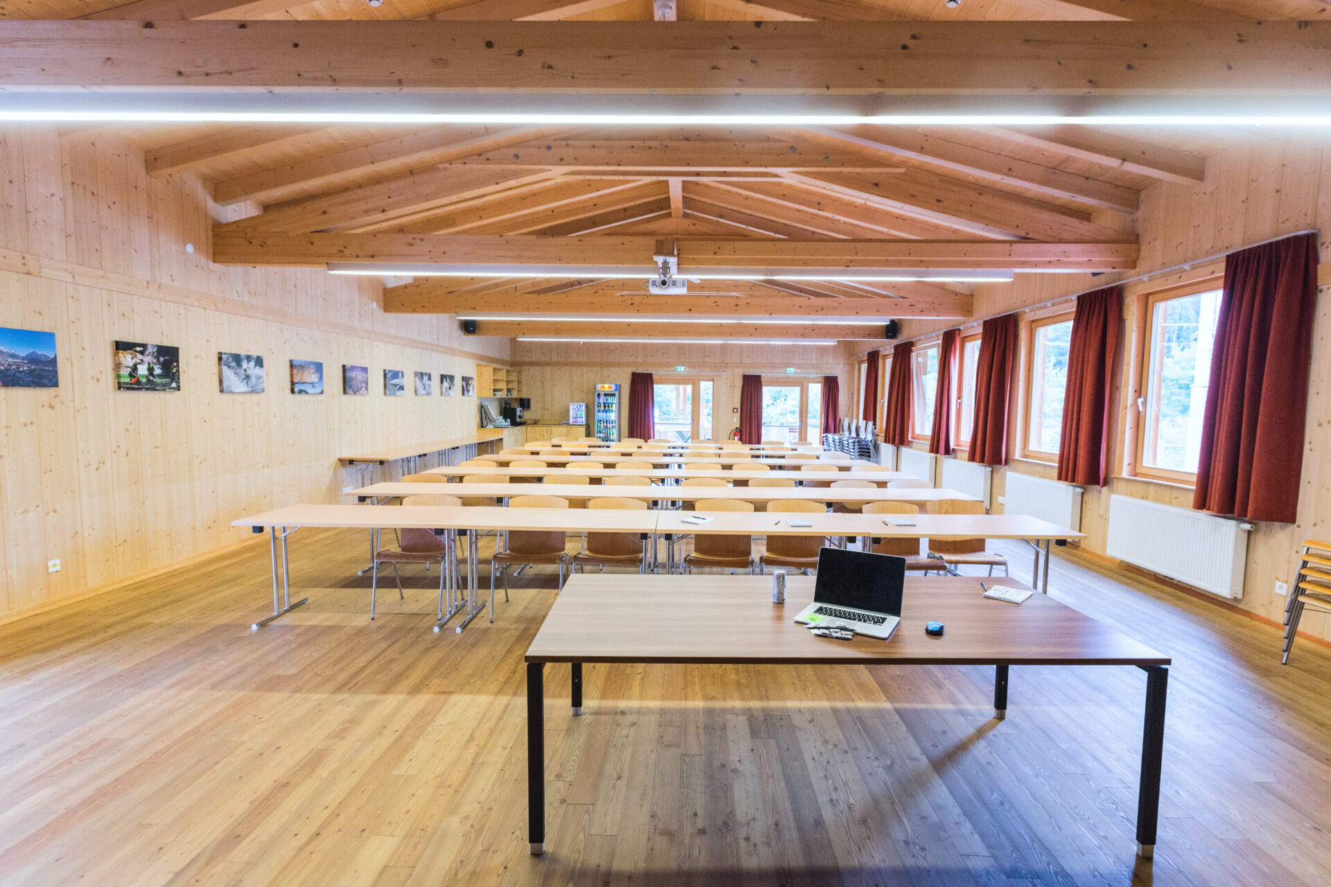Seminar room with wooden walls, tables and chairs in the Meeting Lodge of AREA 47, Ötztal, Tyrol