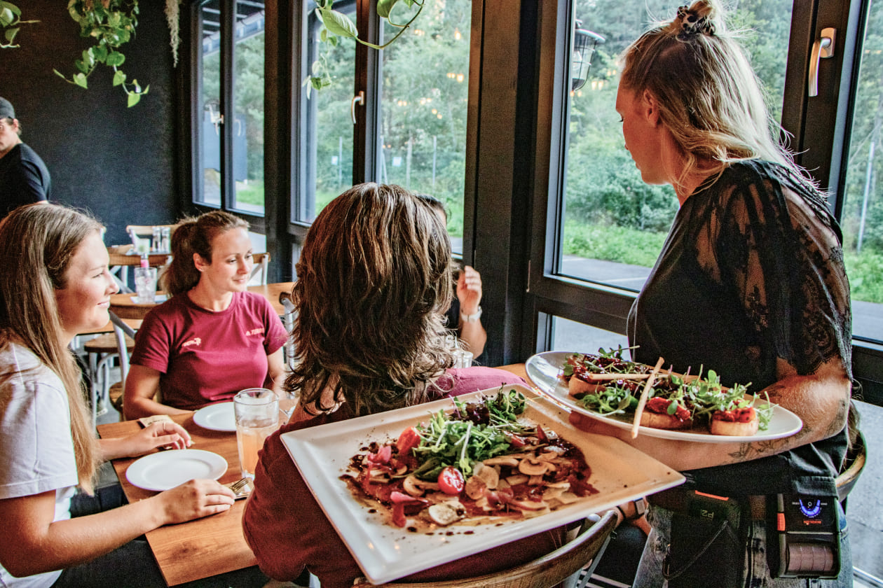 Waitress serves food in a restaurant in AREA 47, Ötztal, Tyrol