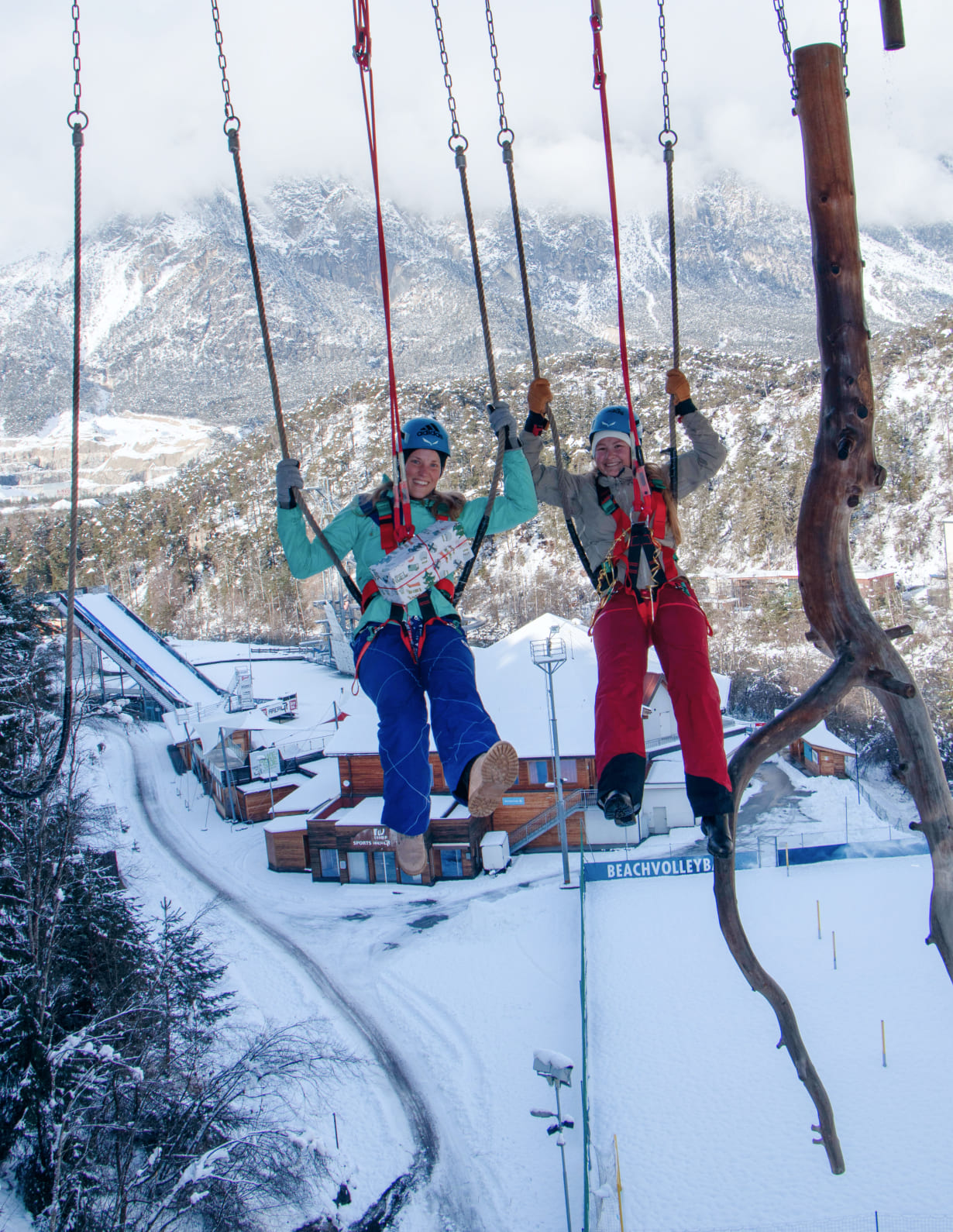 Two women on the giant swing at AREA 47 in snowy Ötztal, Tyrol