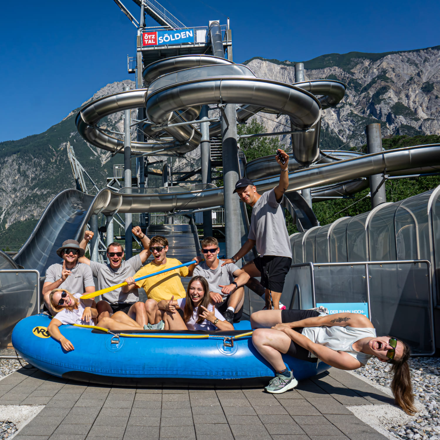 Gruppe von Personen in einem blauen Raft vor dem Wasserrutschenturm der AREA 47 im Ötztal, Tirol