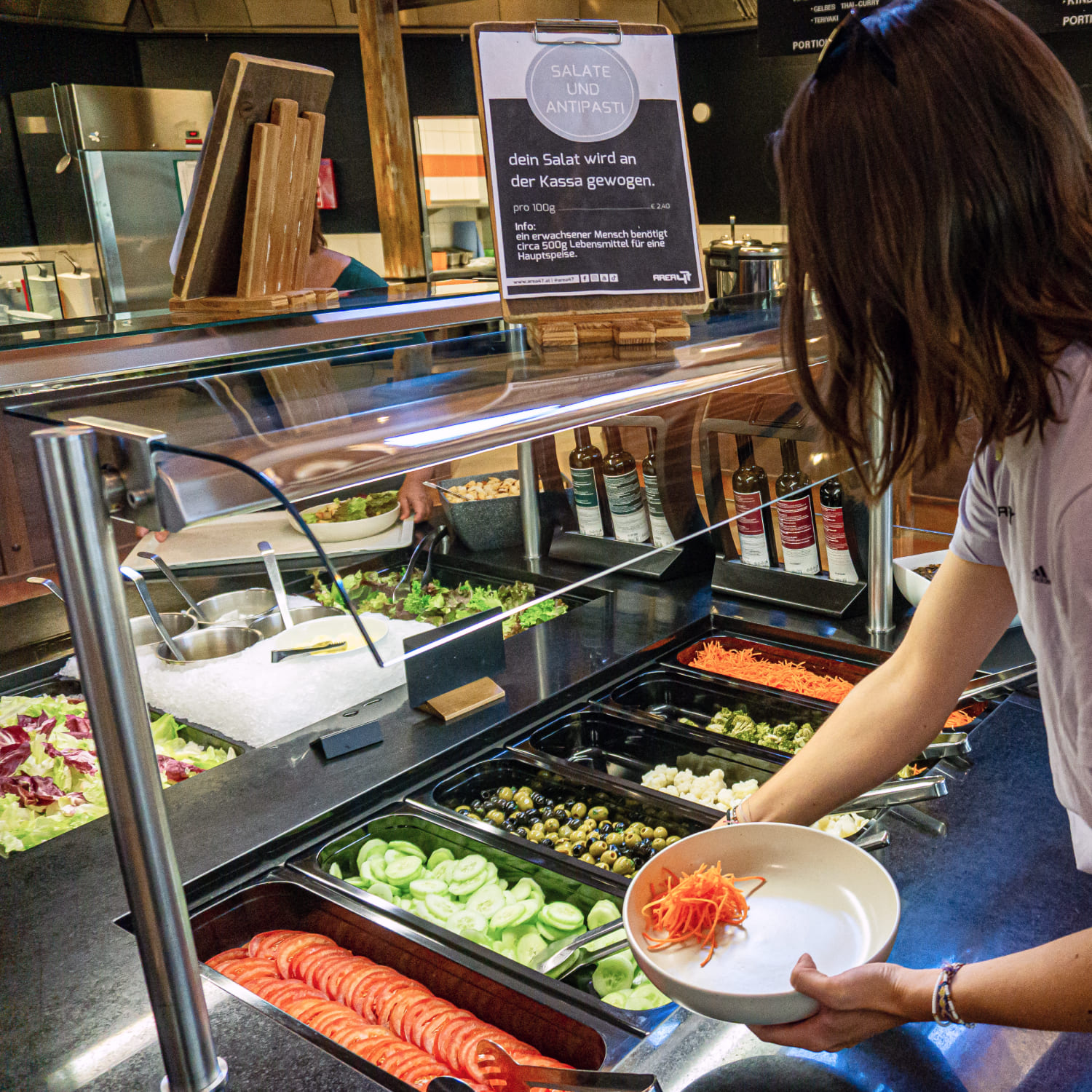 Salatbuffet im Lakeside Restaurant der AREA 47, eine Person befüllt ihren Teller, Ötztal, Tirol