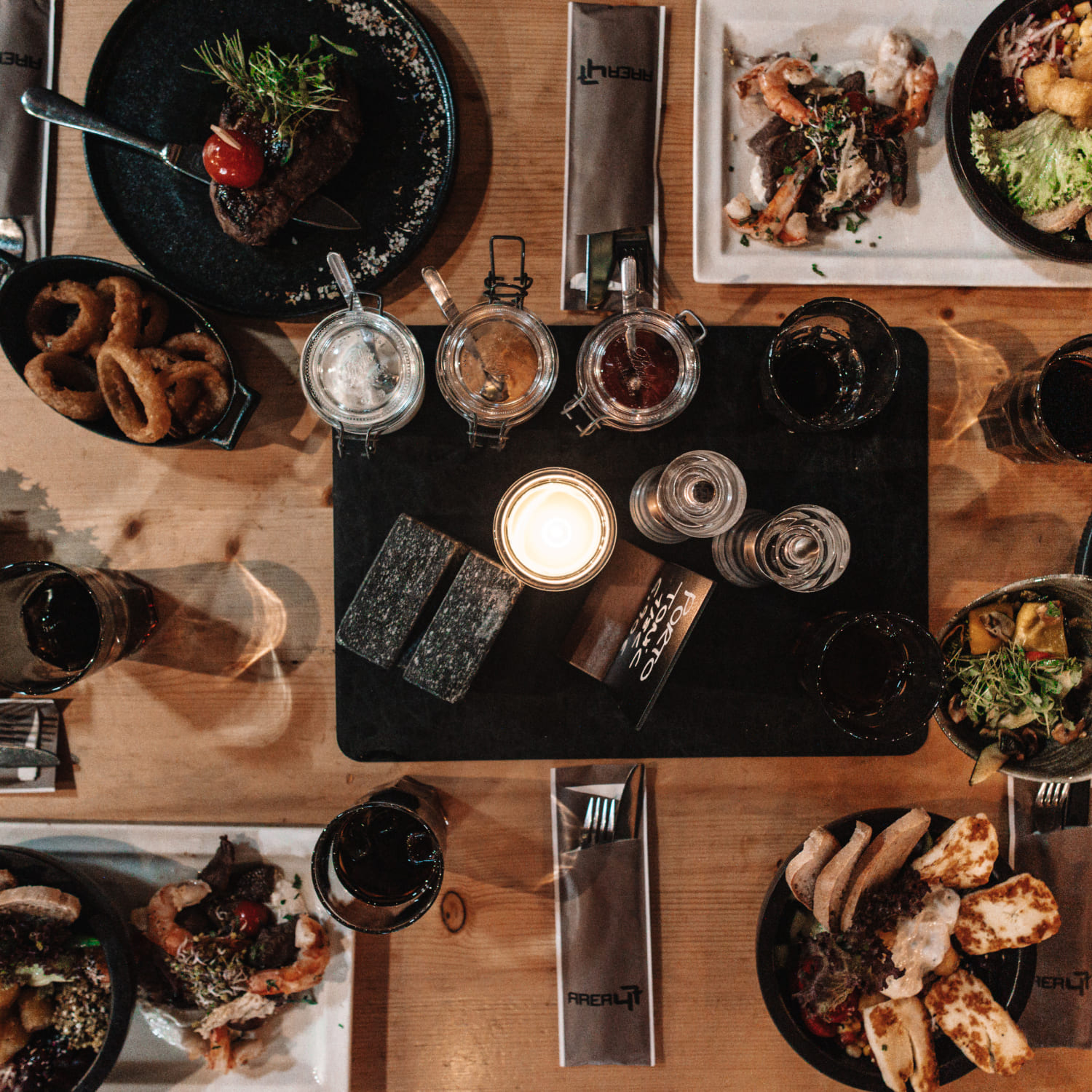 Tisch mit verschiedenen Speisen und Getränken im River Haus Bar & Grill der AREA 47, Ötztal, Tirol