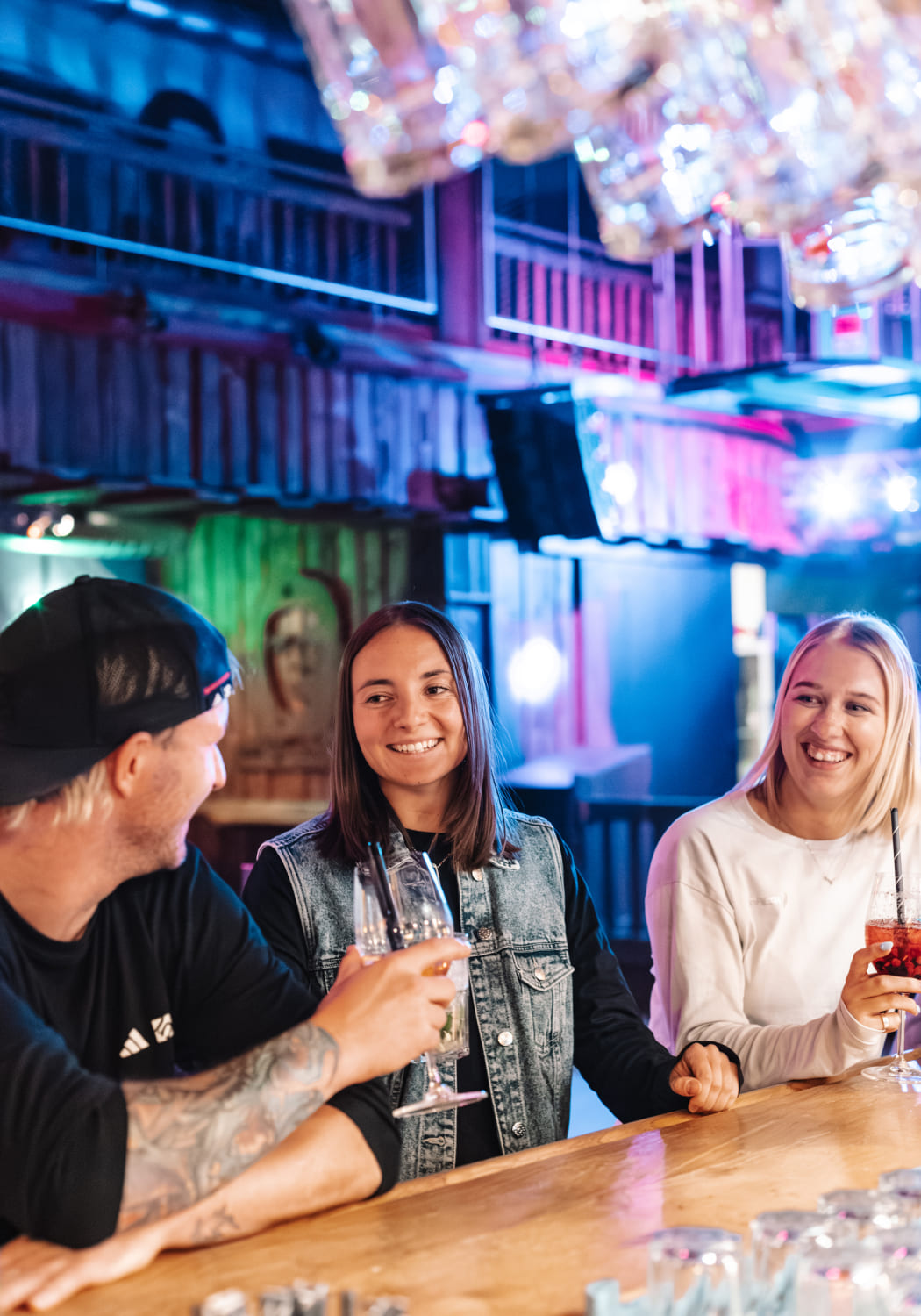 Drei Personen an der Bar im River Haus Bar & Grill der AREA 47, Ötztal, Tirol