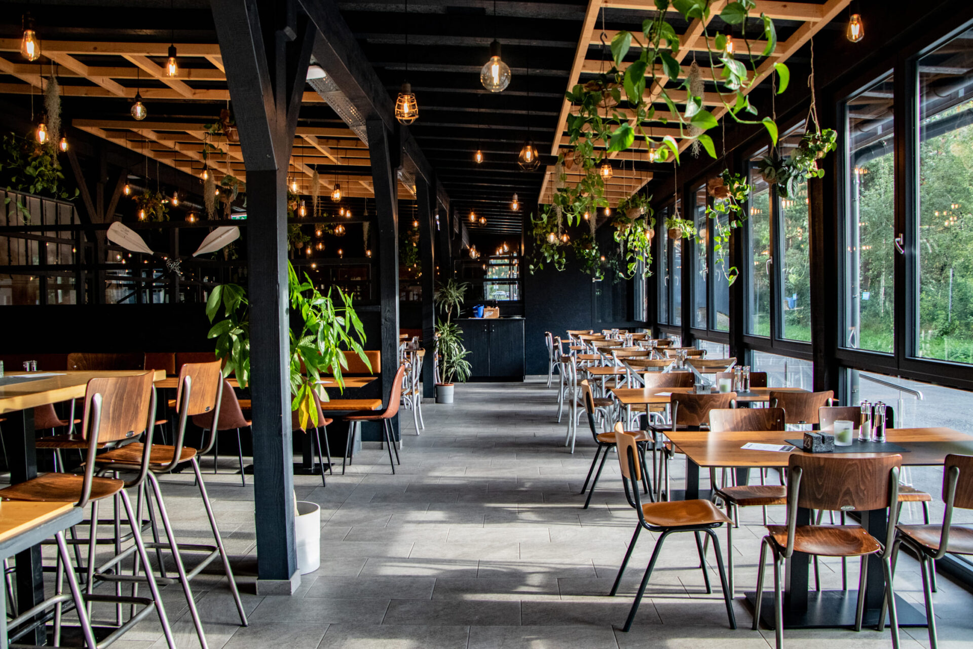 Innenansicht des River Haus Bar & Grill in der AREA 47 mit Pflanzen und Sitzbereichen, Ötztal, Tirol