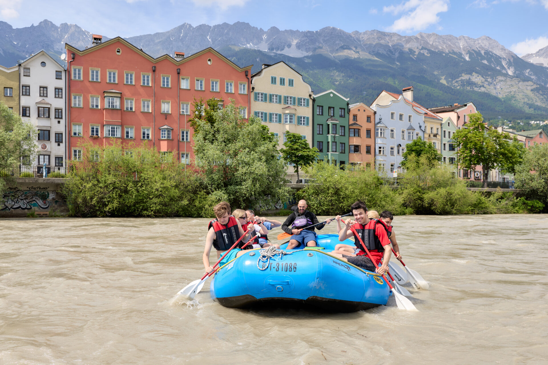 Rafting in Innsbruck – Blick vom Inn auf Stadt und Berge während der Tour